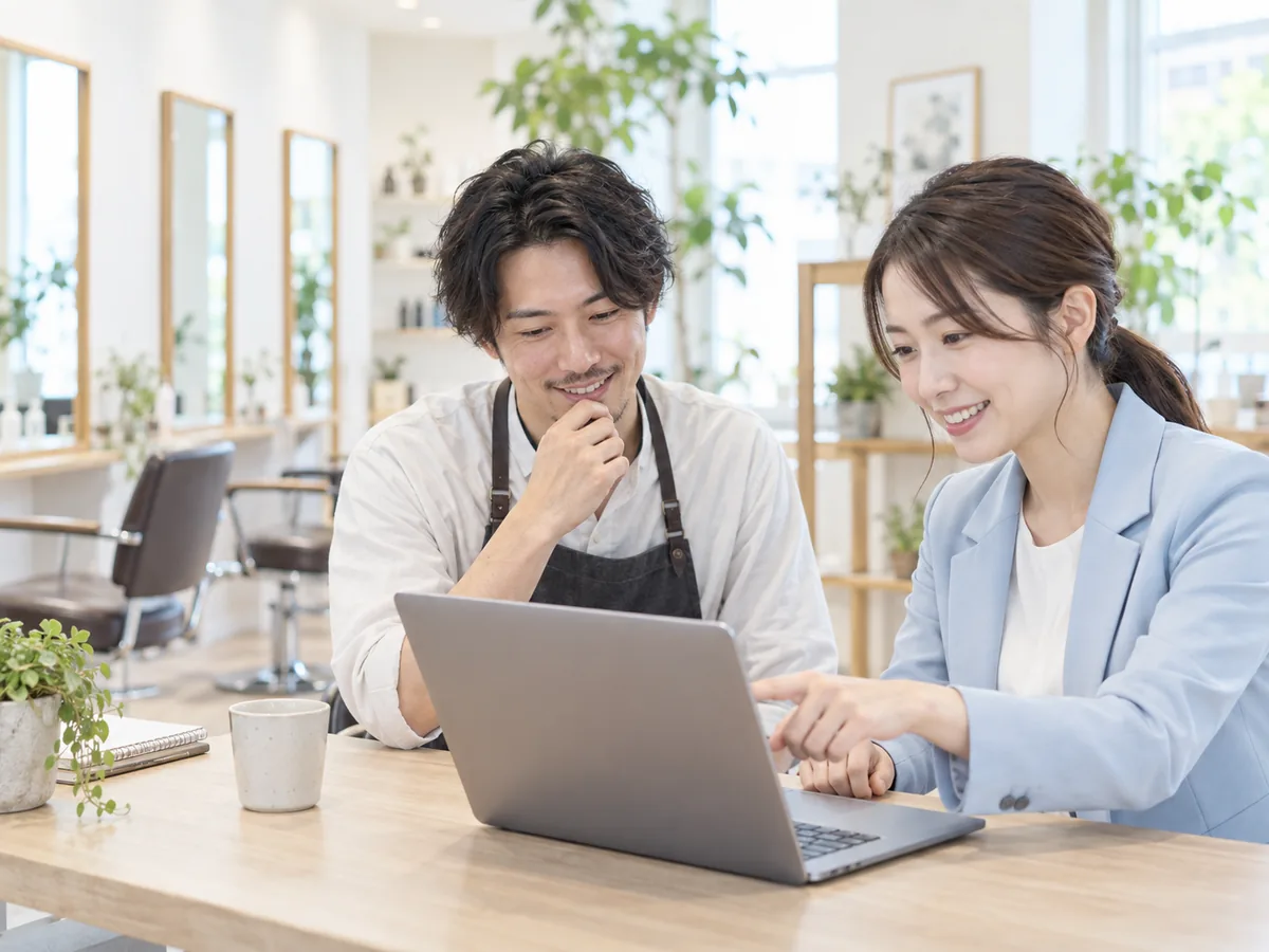 店舗オーナーと担当者がホームページを相談する様子